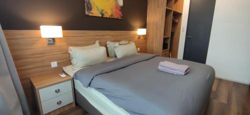 怡保H&W Sunway Onsen Suite Tambun Sunway City Ipoh的一间卧室配有一张床和一个带两盏灯的床头柜。