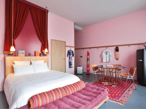 圣旺巴黎普赛MOB酒店的一间卧室配有一张带粉红色墙壁的大床