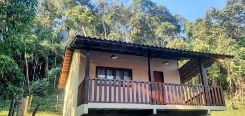 维奥康德马奥Chalé Céu de Minas的森林中带阳台的小房子