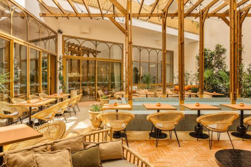 巴黎Bloom House Hôtel & SPA的一间带桌椅的餐厅和一个游泳池