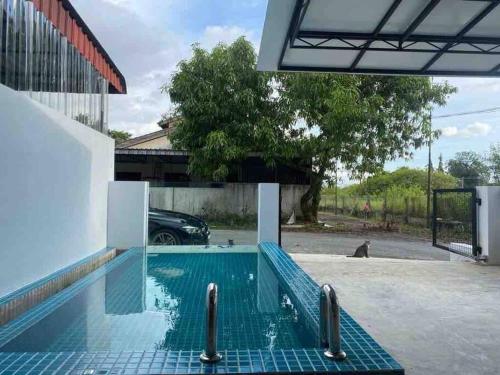 甘文丁Zen Retreat Glass Pool Villa的大楼旁停车场的游泳池