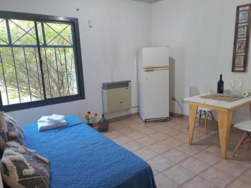 卢汉德库约Rincón Verde Chacras de Coria的客房设有床、桌子和冰箱。