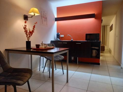 拉罗什-阿登Hebergement confort Comfortlogies La Fontanella的一间带桌椅的用餐室和一间厨房