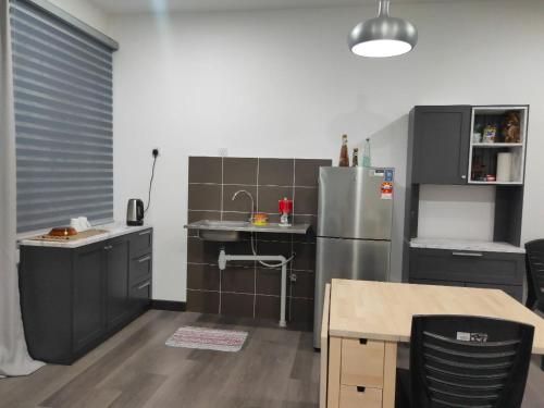 加影Vista Bangi NAQ Homestay - Studio Near UKM的厨房配有不锈钢冰箱和桌子
