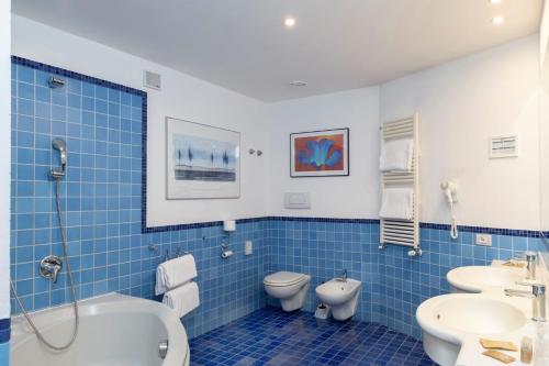 奥斯塔快捷奥斯塔东酒店的蓝色瓷砖浴室设有卫生间和水槽