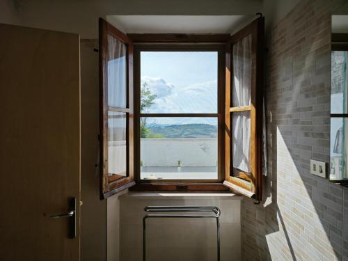 佩萨罗San Rocco Country House的浴室的窗户,前面有散热器
