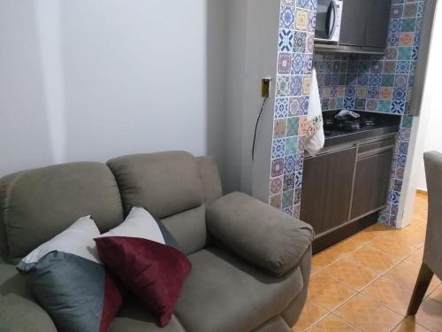 伊塔佩马Pequeno, más aconchegante的客厅配有带枕头的沙发