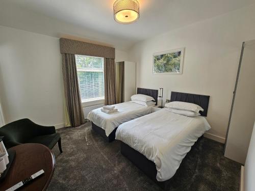 斯塔福德ABBEY HOTEL的酒店客房,配有两张床和椅子