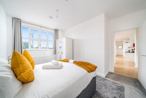 沃特福德Luxury 2 Bedroom Apartment Free Parking, Netflix, Sleeps 6的白色卧室配有一张带黄色枕头的大床