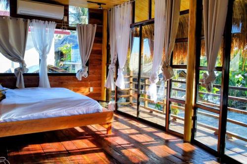 卢纳将军城Ysla Dapeng Siargao的一间设有床铺的卧室,位于带窗户的房间内