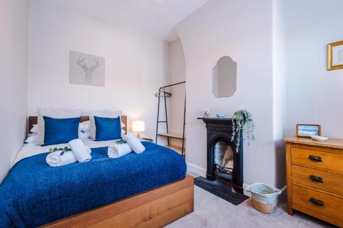 切斯特Central 2-bed home in Chester by 53 Degrees Property - Amazing location, Ideal for Couples - Sleeps 4!的一间卧室配有蓝色的床和壁炉