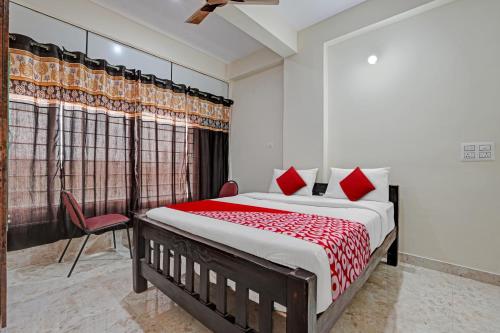班加罗尔Oyo Flagship Sri Chowdeshwari Boarding And Lodging的一间卧室配有一张带红色枕头的大床