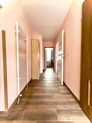 BrzezinyApartament 4 osobowy obok Szpitala Brzeziny 2 pokoje Prywatna łazienka i kuchnia 32m2的走廊设有粉红色的墙壁和瓷砖地板