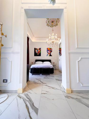 卡塔尼亚Ricci Palace Suites的一间卧室配有一张床和一个吊灯
