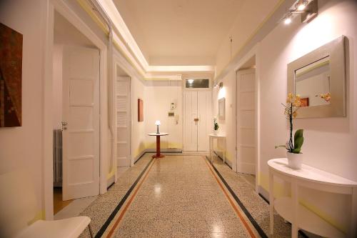 巴里GUESTHOUSE GRANDI STAZIONI _ bari centro s.l._的走廊设有白色门,铺有瓷砖地板