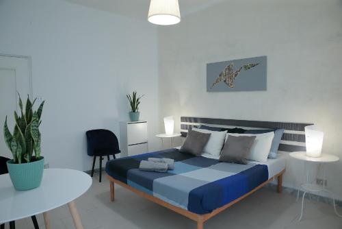 巴里GUESTHOUSE GRANDI STAZIONI _ bari centro s.l._的一间卧室配有一张蓝色的床和一张桌子