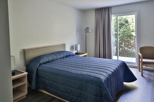 MascoucheMotel Mascouche的酒店客房设有蓝色的床和窗户。