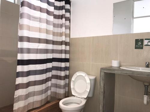 IllimoEcolodge Huaca Piedra的浴室设有卫生间、水槽和淋浴帘