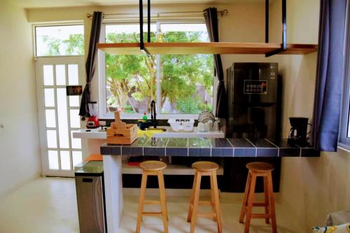 Brisas de ZicatelaMangal Suites的厨房配有带凳子和水槽的台面