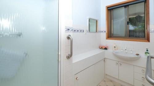 MarloMarlo at the Beach的白色的浴室设有水槽和淋浴。
