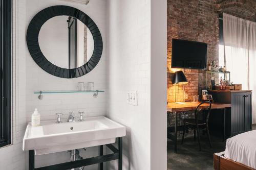 布鲁克林威思酒店的一间带水槽和镜子的浴室以及一间卧室