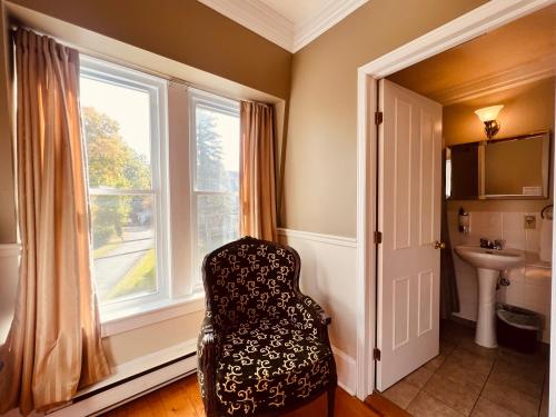 梅戈格湖泊庄园酒店的浴室位于窗户前,配有椅子