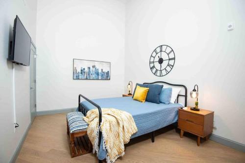 伯明翰Lovely Condo in Downtown Birmingham的卧室配有一张床,墙上挂着一个钟
