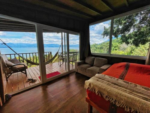 圣佩德罗拉拉古纳Refugio del Volcan Casitas的一间卧室设有一张床和一个美景阳台