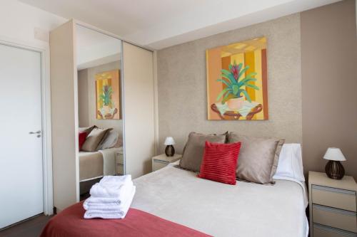 瓜鲁柳斯Sunshine Studio - GRU 2316的卧室配有带红色枕头的白色床