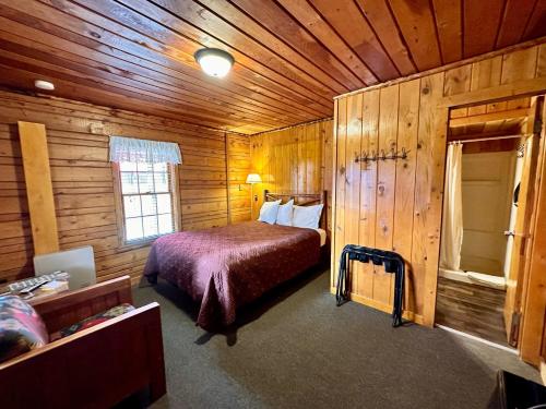 西黄石黄石小屋及房车露营地的小木屋内一间卧室,配有一张床