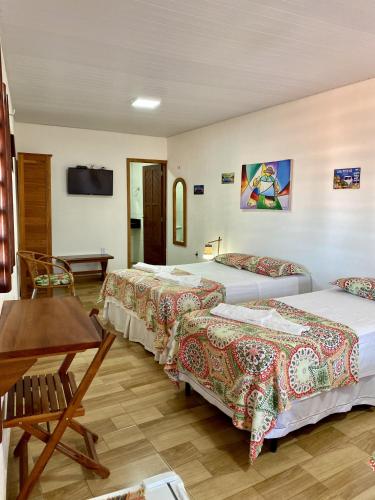 弗雷谢拉斯Pousada São Pedro的酒店客房设有两张床和一张桌子。