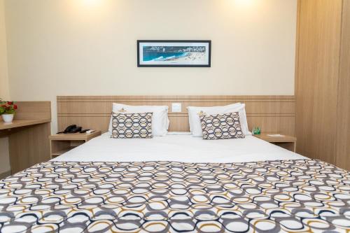 里约热内卢弗鲁米嫩塞酒店的一间卧室配有一张带蓝白色枕头的大床