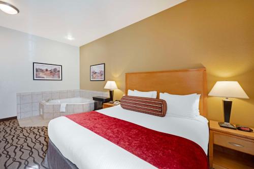 Guymon盖蒙贝斯特韦斯特PLUS酒店的酒店客房配有一张床和浴缸。