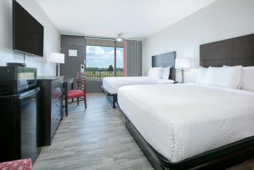 迪亚蒙德黑德Ramada by Wyndham Gulfport I-10 Diamondhead的酒店客房设有两张床和一台平面电视。