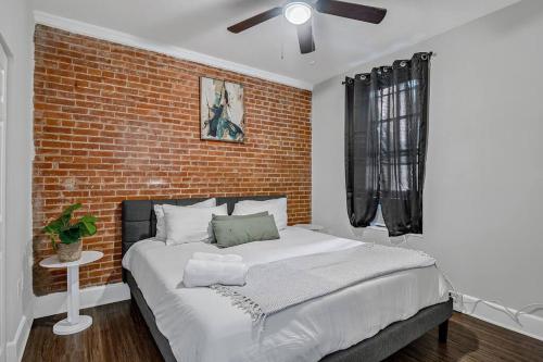 哈里斯堡HBG 1BR: Modern Vintage Gem的一间卧室设有一张带砖墙的大床