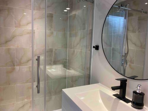 多伦多Grandravine/Beautiful Unit near downtown Toronto的带淋浴、盥洗盆和镜子的浴室