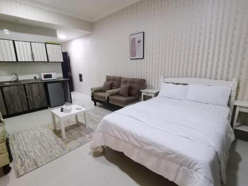 阿吉曼Studio的卧室配有一张白色的大床和一张沙发。