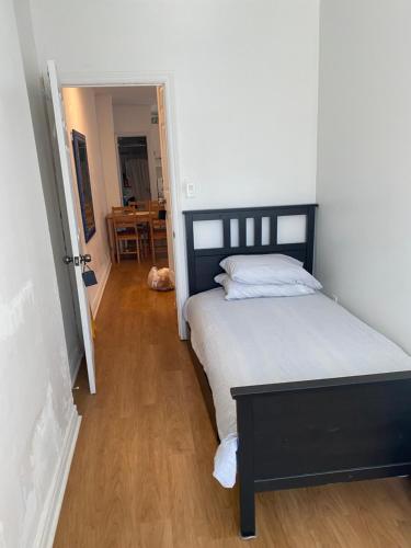 多伦多Private Single Room with Shared Bathroom 536C的一间卧室设有一张大床,铺有木地板