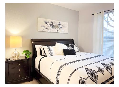 奥兰多Windsor Hills Resort - Magical Atmosphere Condo - 5 min Disney的一间卧室配有一张带黑白色棉被的床