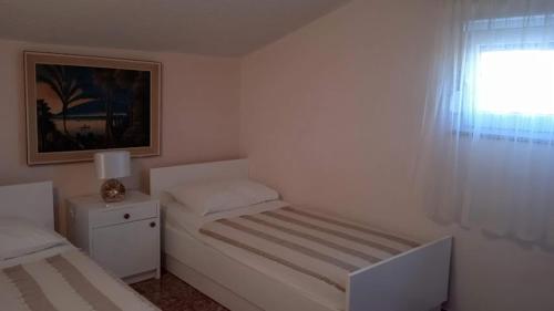 扎格拉维奇Apartments by the sea Cove Ostricka luka, Rogoznica - 11451的一间白色的小卧室,配有床和窗户