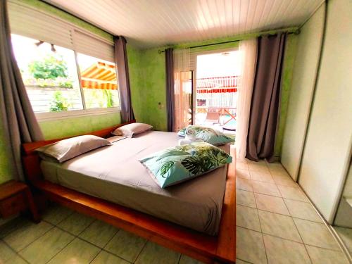 帕皮提TAHITI - Lihei Pool House的一间带床的卧室,位于带窗户的房间内