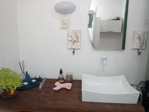 特拉曼达伊Kitnet da Elô的浴室的柜台设有水槽和镜子