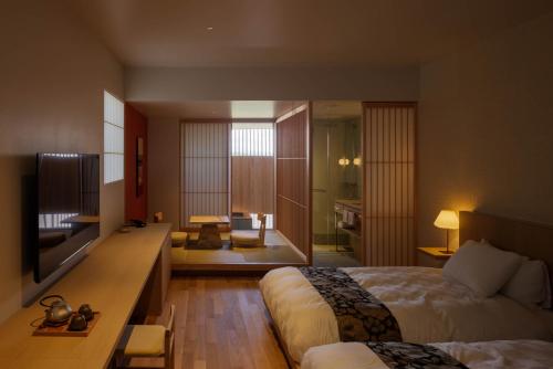 出云市Hotel Kararako的酒店客房设有床和客厅。