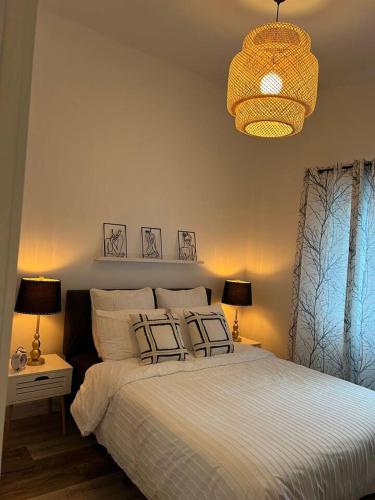 米拉贝尔Le St-Augustin的一间卧室配有一张带两盏灯和吊灯的床。