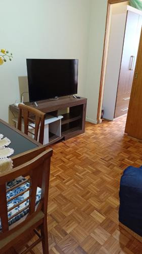 里约热内卢Apartamento não está disponível的客厅配有平面电视和桌子。