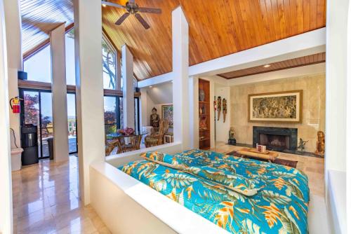 HueloLavish Cliff House with Ocean Views in Haiku, Maui jungle的一间卧室设有一张大床和一个壁炉