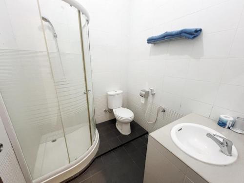 棉兰OASE GUEST HOUSE的带淋浴、卫生间和盥洗盆的浴室