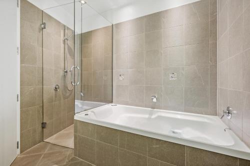 汉默温泉乡村湖泊公寓式酒店的设有带浴缸和淋浴的浴室。