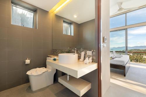 苏梅岛TWO SISTERS HILL Villa - Spectaculaire vue sur mer的一间带水槽和卫生间的浴室以及窗户。