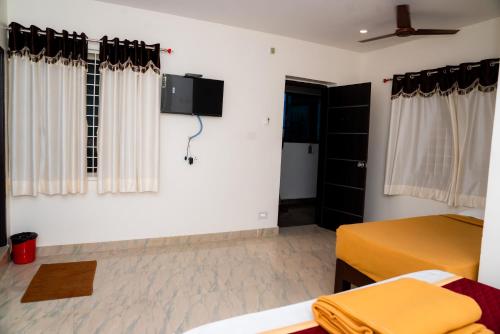 蒂鲁帕蒂Hotel Sitar Grand的一间卧室设有两张床,墙上配有电视。